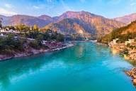 Crystal-clear Ganga River surrounded by mountains in Rishikesh, one of the best budget travel destinations in India.